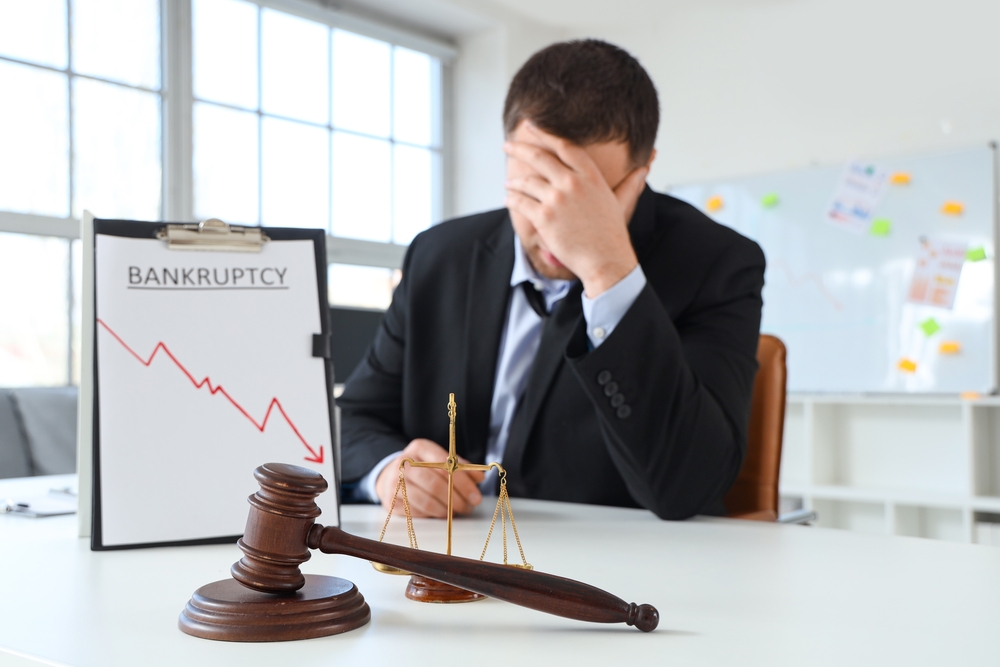 Judge's gavel with justice scales on table of bankrupt businessman in office